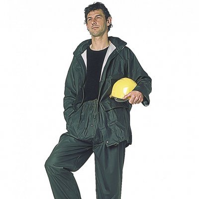 Homem com fato de trabalho verde escuro e capacete amarelo em cima de bloco de cimento