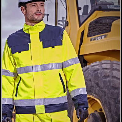 homem com roupa de alta visibilidade perto de veículo de construção