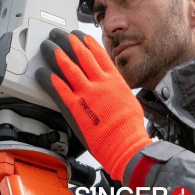 Mão com luva de segurança laranja e cinza segurando equipamento cinza com texto SINGER safety