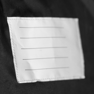 Etiqueta branca com linhas pretas costurada em tecido preto