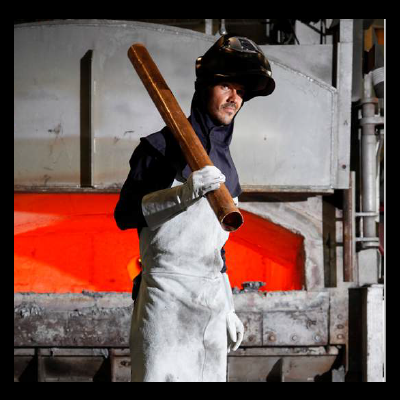 Homem com equipamento de proteção e tubo de metal em ambiente industrial
