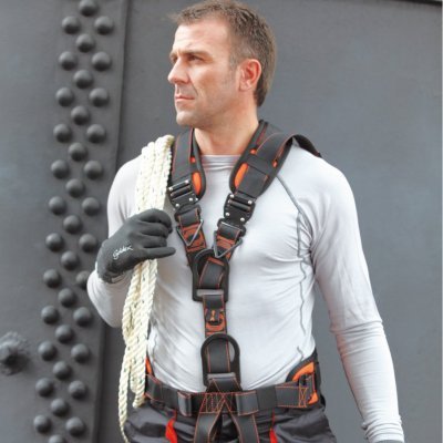 Homem com arnês de segurança preto e laranja, luvas e corda branca