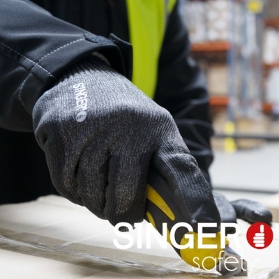 Mãos com luvas de segurança cinzentas a usar faca para abrir embalagem em armazém