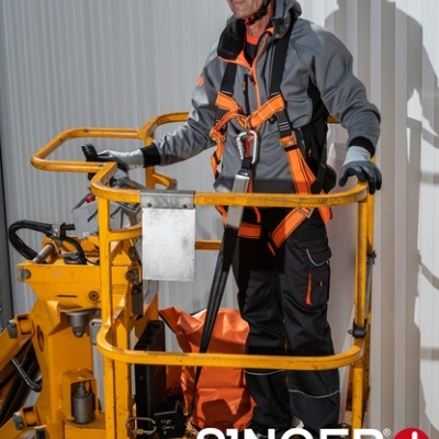 Homem em fato de segurança e capacete branco numa plataforma de elevação amarela com logotipo SINGER safety