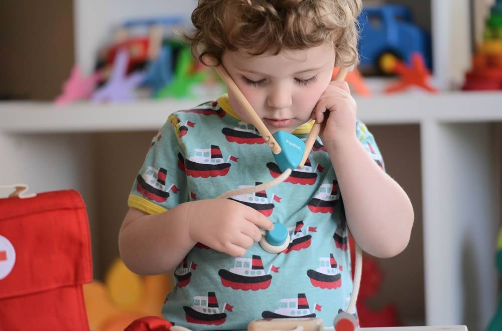 Set de Médico Criança a brincar com brinquedo de médico de madeira