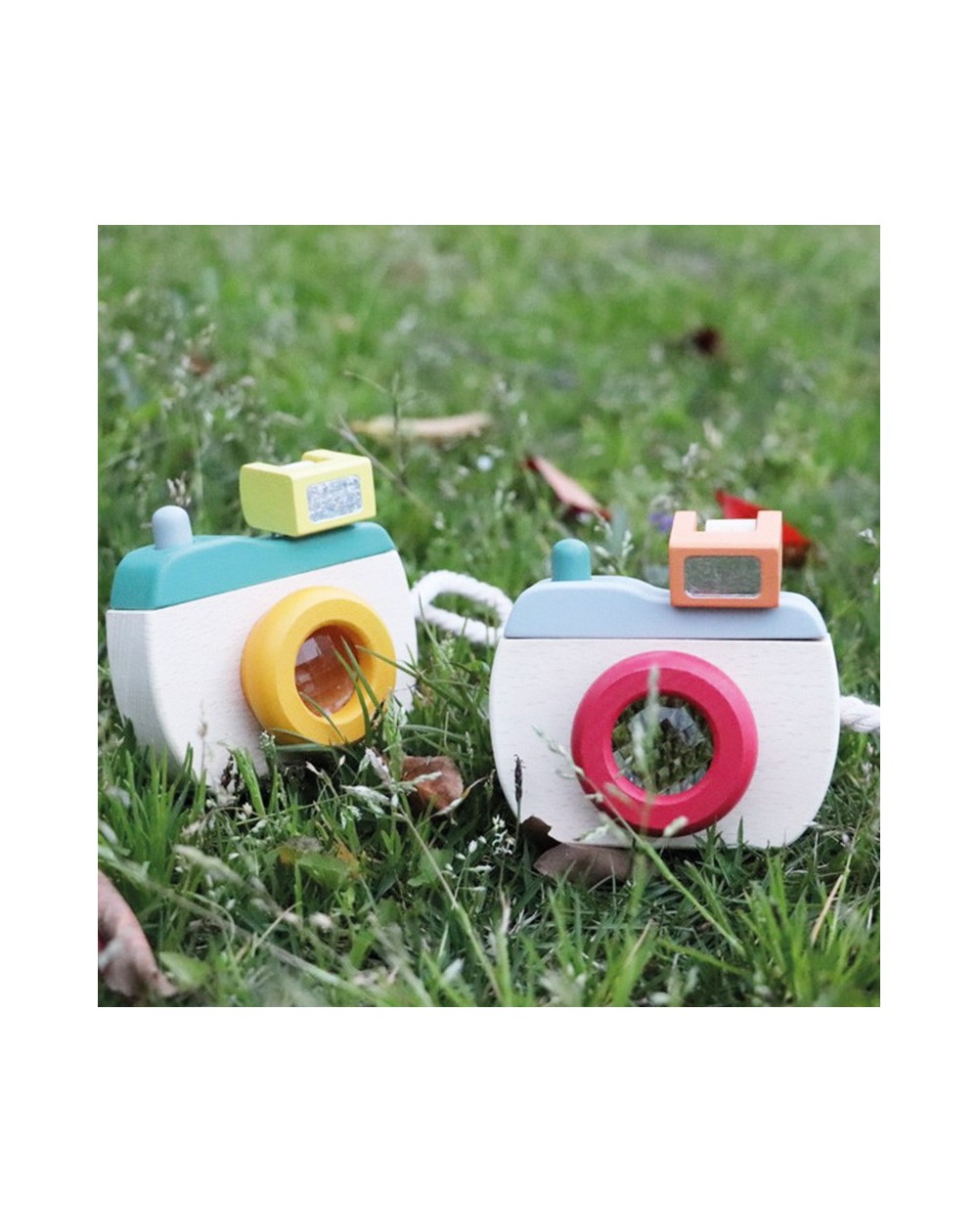 Máquina Fotográfica de Madeira Brinquedos de madeira em forma de câmeras fotográficas coloridas sobre relva verde