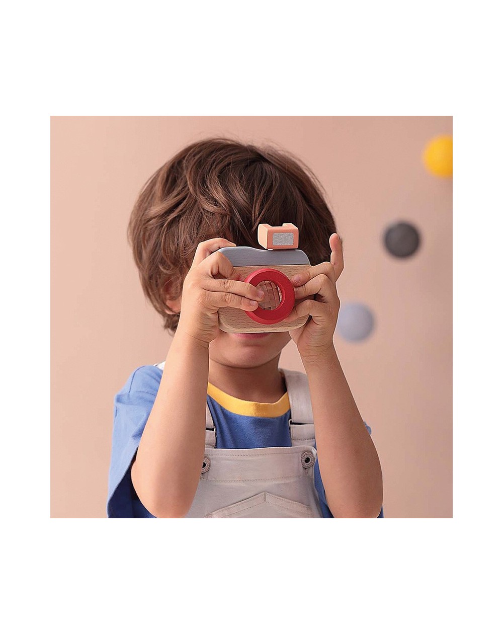 Máquina Fotográfica de Madeira Criança a segurar câmara fotográfica de brinquedo em madeira