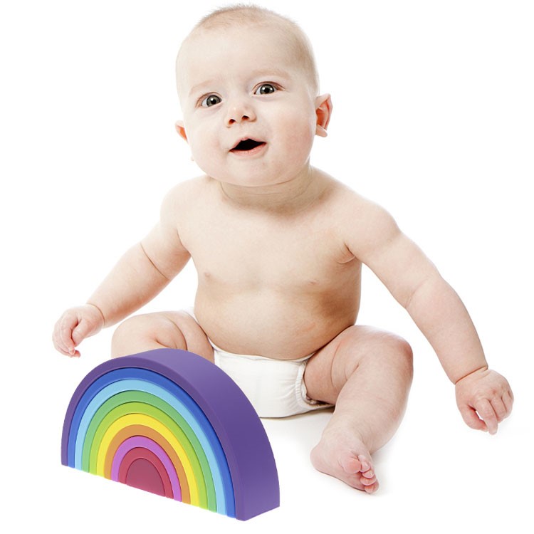 Arco Iris 10 Pcs Bebé com fralda branca sentado ao lado de brinquedo colorido em arco-íris