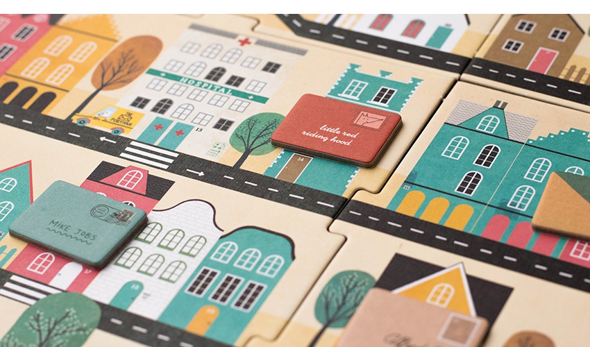 Jogo O Carteiro Jogo de tabuleiro com peças coloridas representando casas, ruas e placas com texto