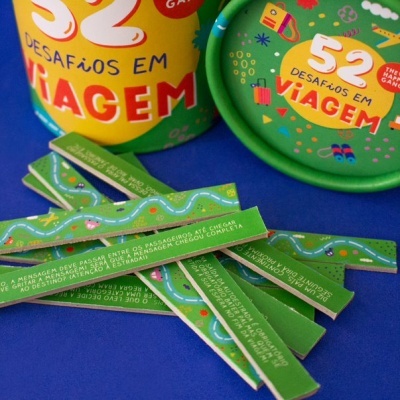 Jogo 52 Desafios em Viagem com peças verde e embalagem colorida sobre superfície azul