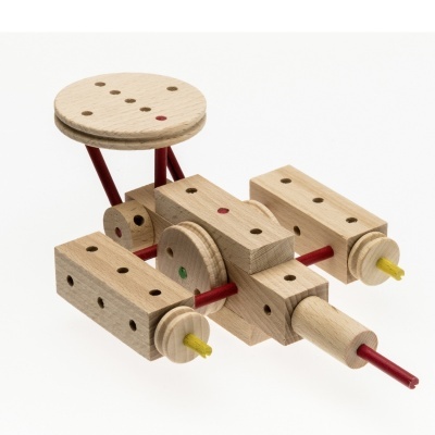 Brinquedo de madeira com peças retangulares e circulares unidas por hastes coloridas.