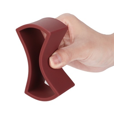 Utensílio de silicone castanho-avermelhado curvo na mão