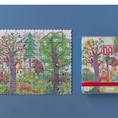 Quebra-cabeças ilustrado com 35 peças e embalagem com o título 'IDA' lado a lado sobre superfície azul.