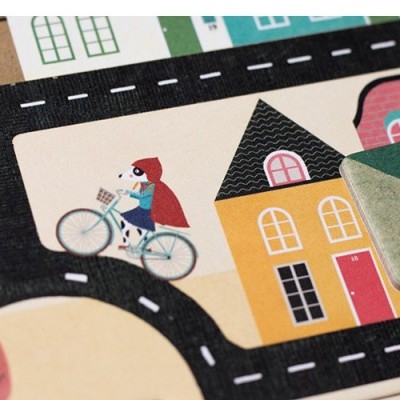 Tabuleiro de jogo infantil com ruas, casas e ciclistas, incluindo envelope de papel verde.