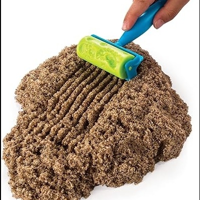 Rolo plástico azul e verde a criar textura numa massa castanha tipo areia.