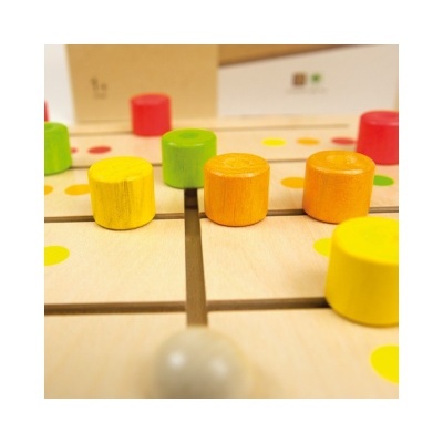 Jogo de tabuleiro de madeira com peças coloridas e marcas redondas no tabuleiro