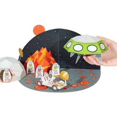 Brinquedo de papel espacial com astronautas, iglu, veículo lunar e disco voador verde.