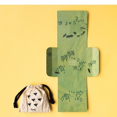 Saco de tecido bege com cordão preto e padrão de corações pretos ao lado de molde verde