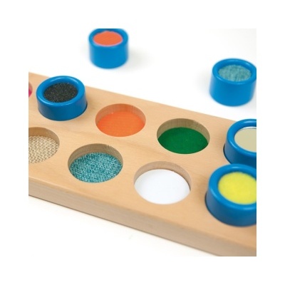 Painel de madeira com círculos coloridos e tampas azuis