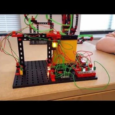 Montagem eletrónica com fios e botões numa bancada de madeira