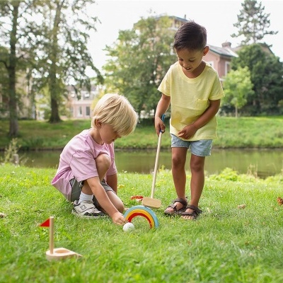 Crianças brincando com brinquedo de golfe infantil de madeira no parque ao ar livre