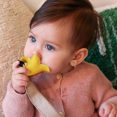 Bebé com brinquedo amarelo em forma de banana