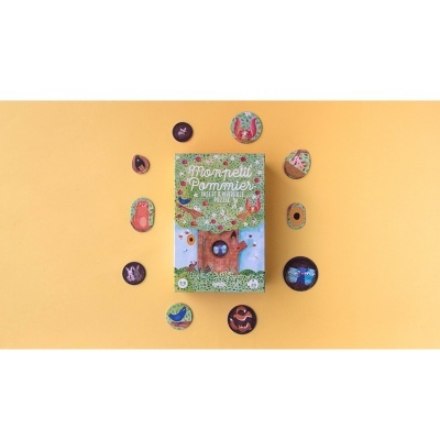 Livro infantil com botões decorativos coloridos sobre fundo amarelo