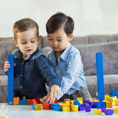 Crianças a brincar com blocos de construção coloridos numa mesa