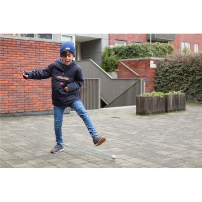 Criança com casaco azul e gorro azul a brincar ao ar livre