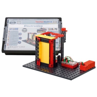 Kit de eletrónica Fischer Technik com estrutura vermelha e amarela sobre base perfurada preta e caixa com etiqueta Electronics.