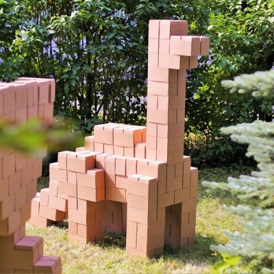 Esculturas de dinossauros em blocos de madeira num jardim