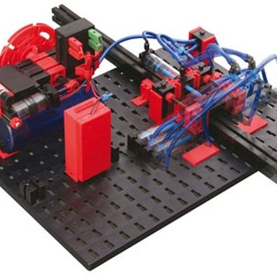 Kit mecânico educacional com componentes vermelhos, pretos e tubos azuis numa base preta perfurada