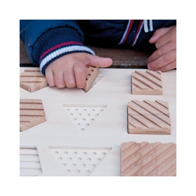Jogo de encaixe de madeira com peças texturizadas e criança a brincar