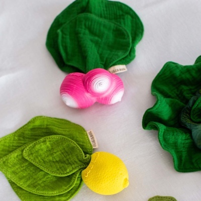 Brinquedos macios e coloridos em forma de legumes e frutas sobre fundo branco