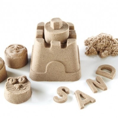 Brinquedos de areia com formas redondas com rostos, castelo de areia e letras que formam a palavra 'SAND'