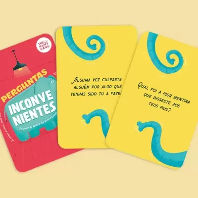 Cartas de jogo 'Perguntas Inconvenientes' com texto em português sobre fundo amarelo