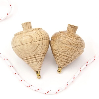 Dois piões de madeira com detalhes dourados e corda branca com linhas vermelhas