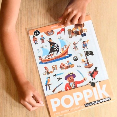Livro de autocolantes Poppik Mini Discovery com piratas sobre mesa de madeira