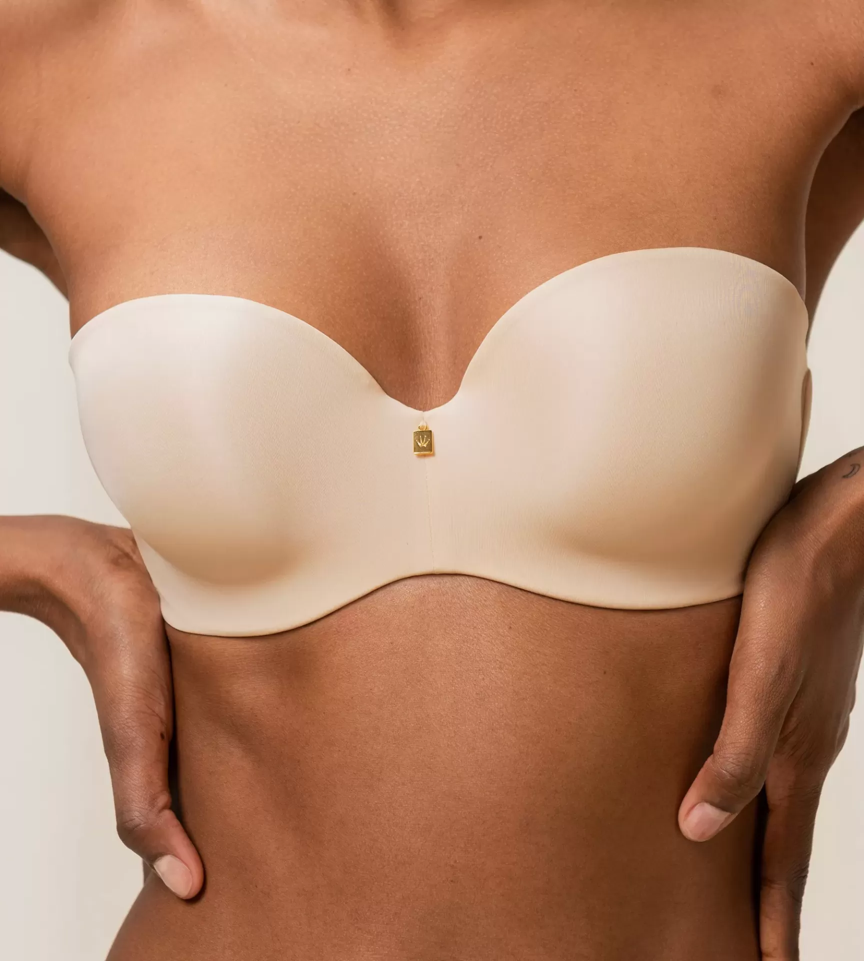 Soutien sem alças bege claro com pendente dourado no centro