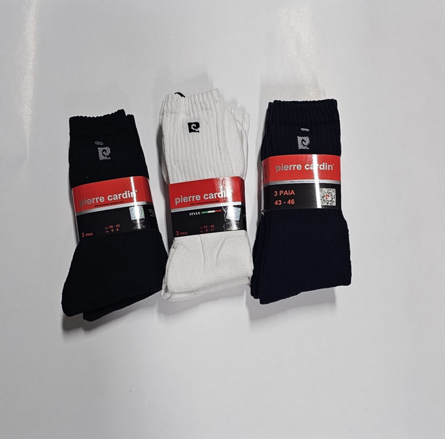 Três conjuntos de meias Pierre Cardin, cores preta, branca e azul com etiquetas vermelhas.