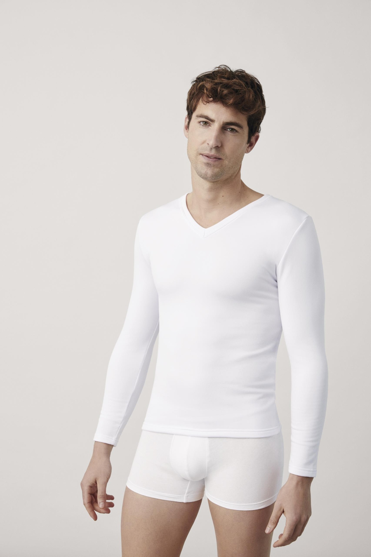 Homem a usar roupa interior branca manga comprida e cuecas boxeador