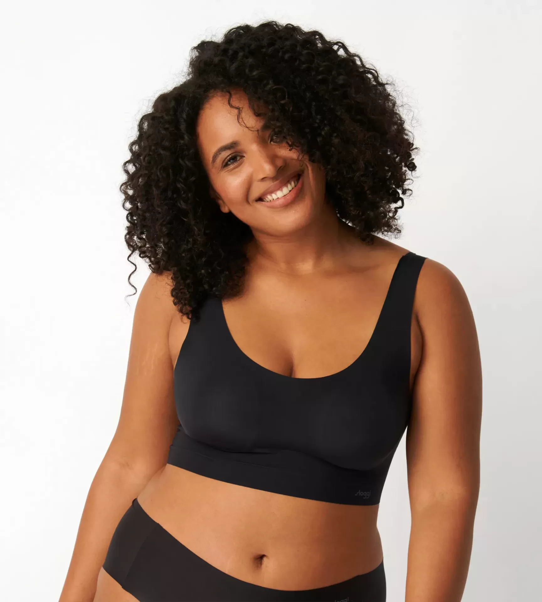 Mulher com soutien desportivo preto e cabelo encaracolado