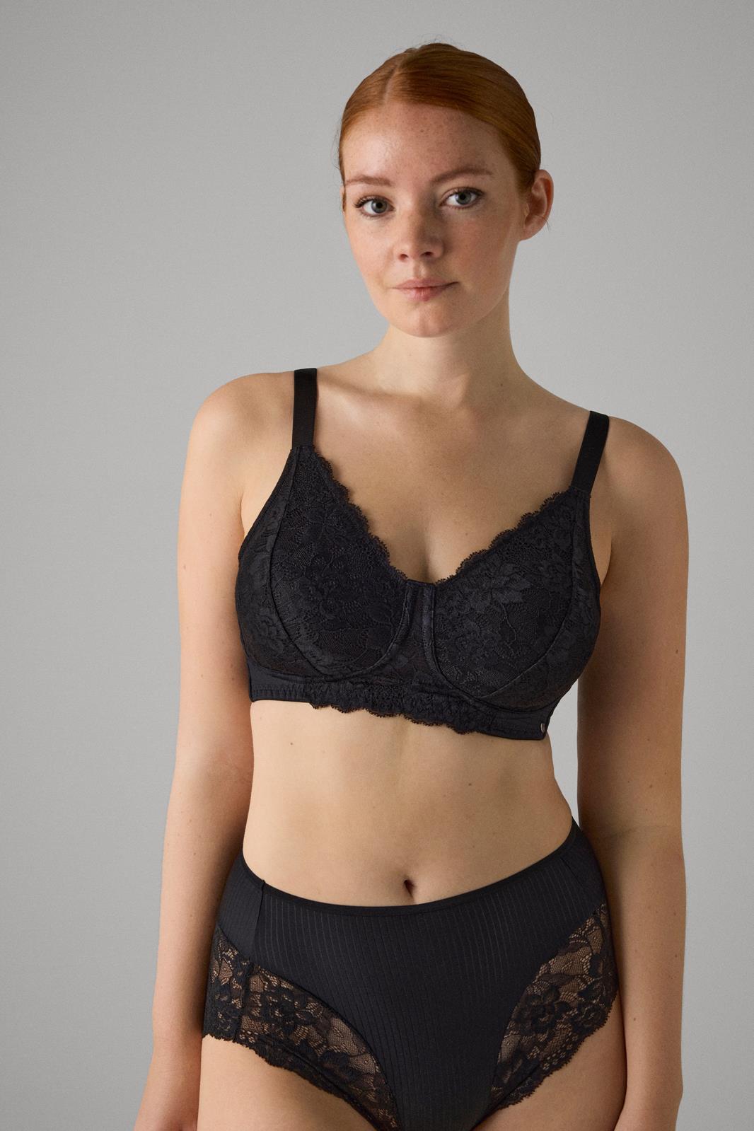 Mulher com conjunto de lingerie preto com renda e padrão listrado