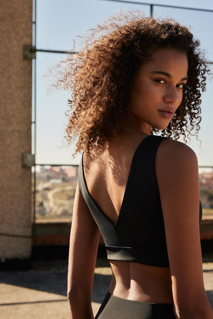 Top desportivo preto com decote em V na parte de trás