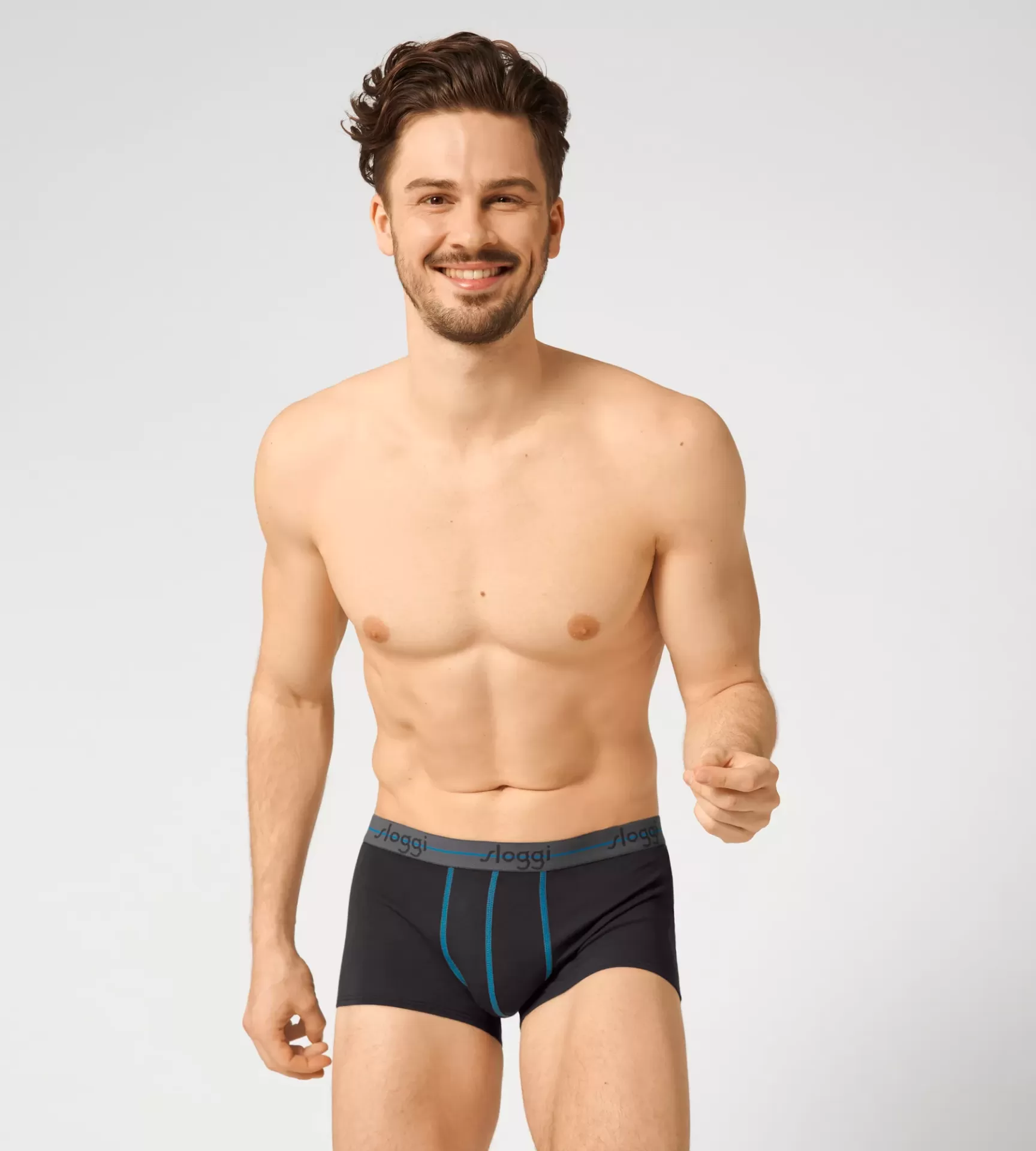 Homem com cuecas boxer pretas com costura e cós cinza em fundo branco