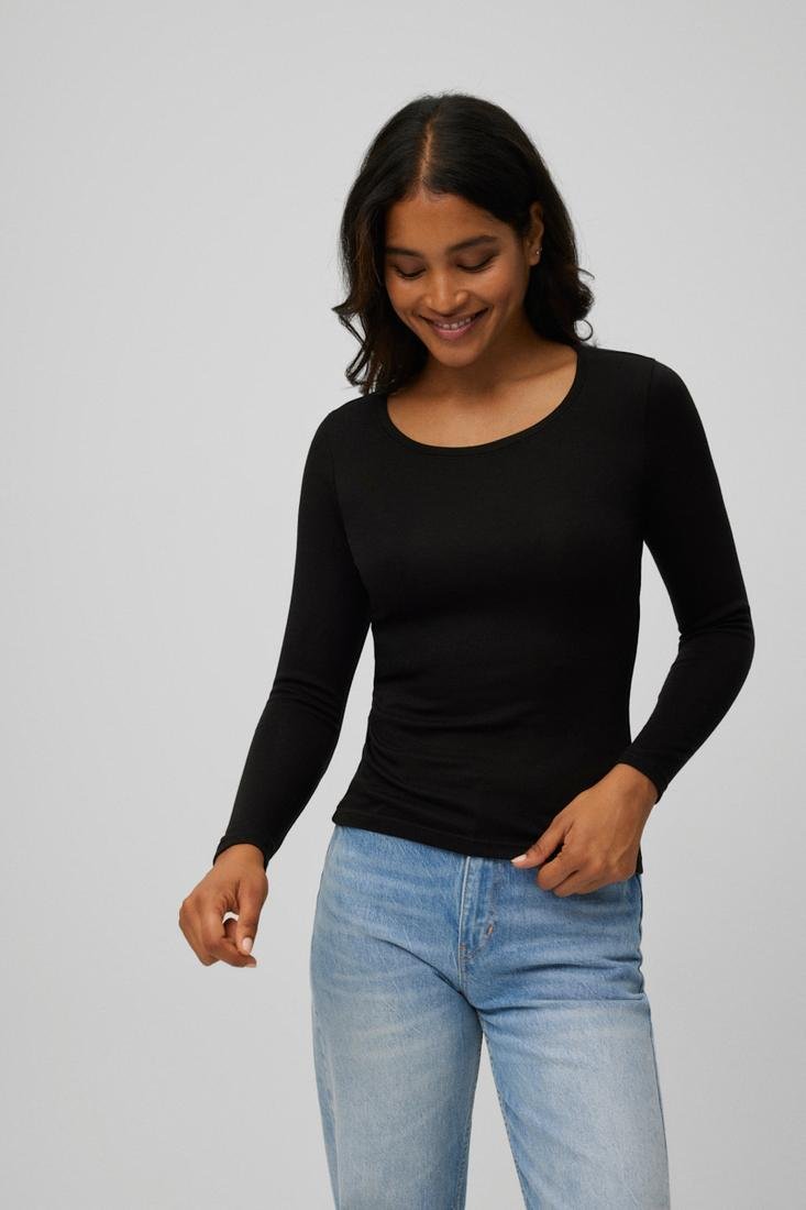 Pessoa com t-shirt preta de manga comprida e calças de ganga azuis claras