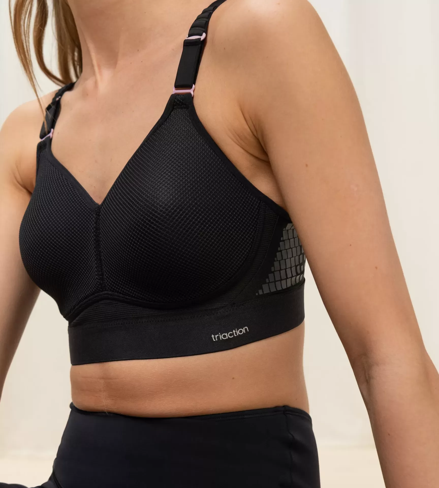 Soutien desportivo preto com alças ajustáveis e padrão geométrico nas laterais