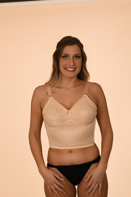 Mulher com sutiã comprido bege com detalhes em renda e calças interiores pretas