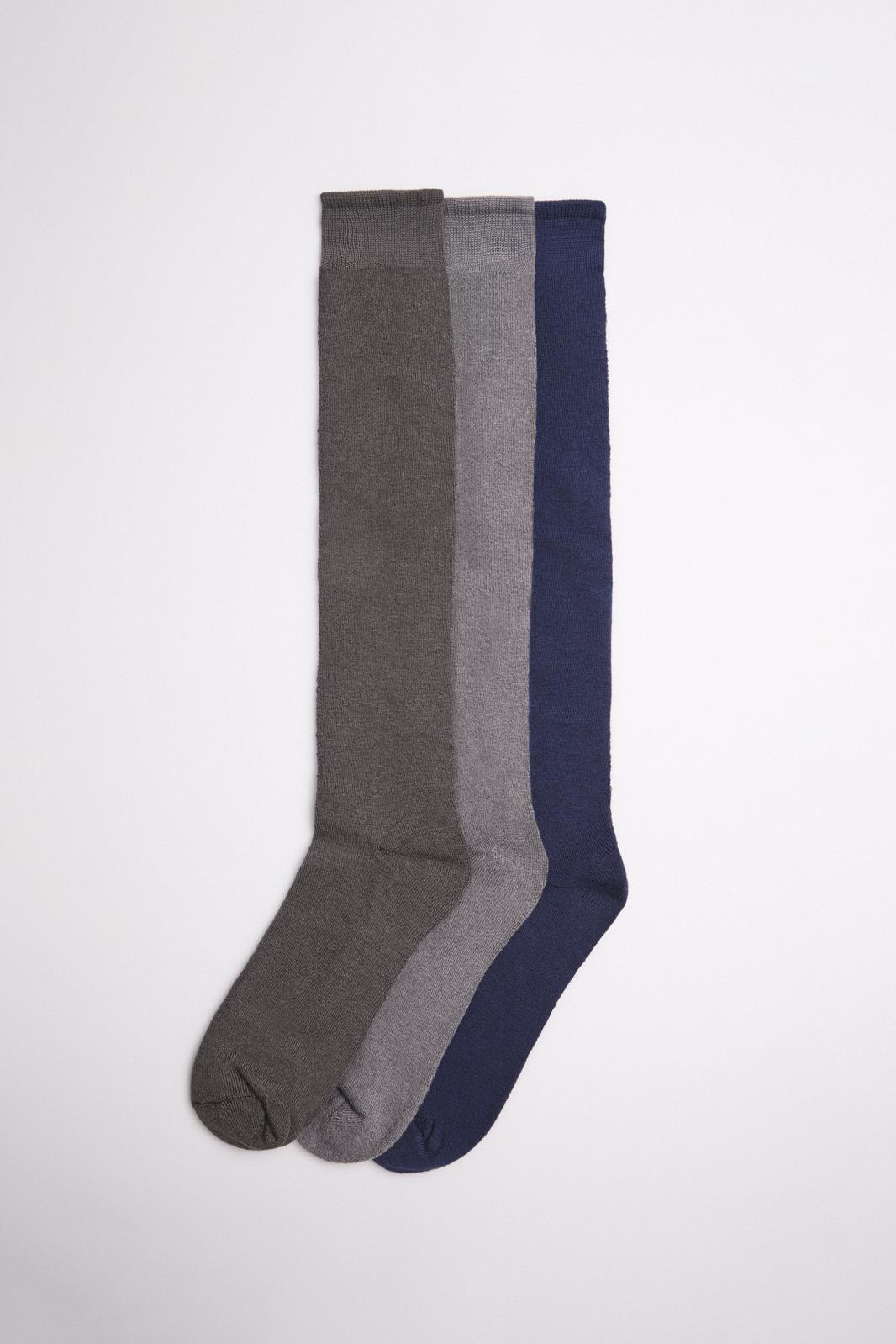 Três pares de meias compridas em cinza escuro, cinza claro e azul escuro sobre fundo branco