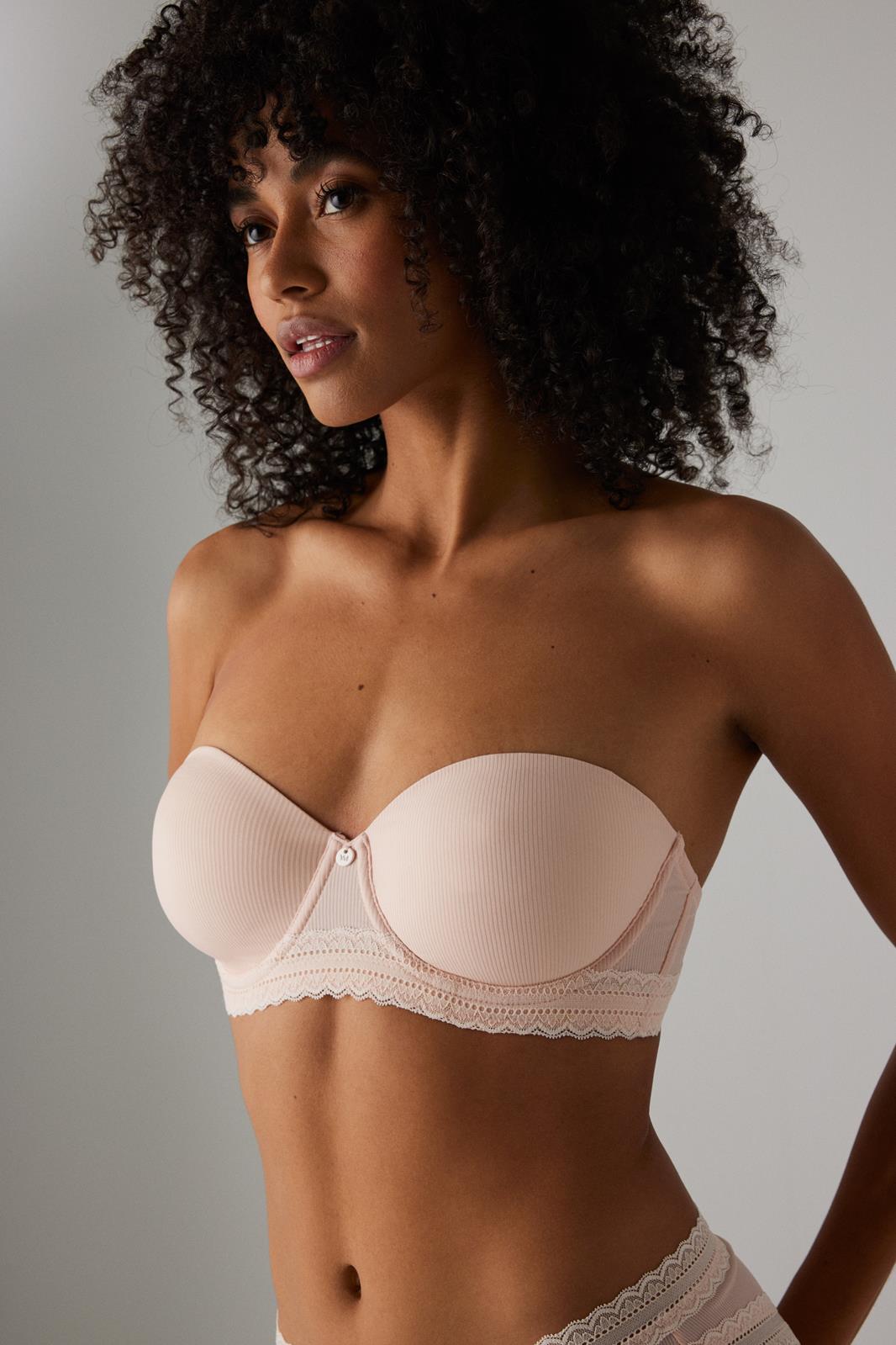 Soutien rosa claro sem alças com renda usado por modelo